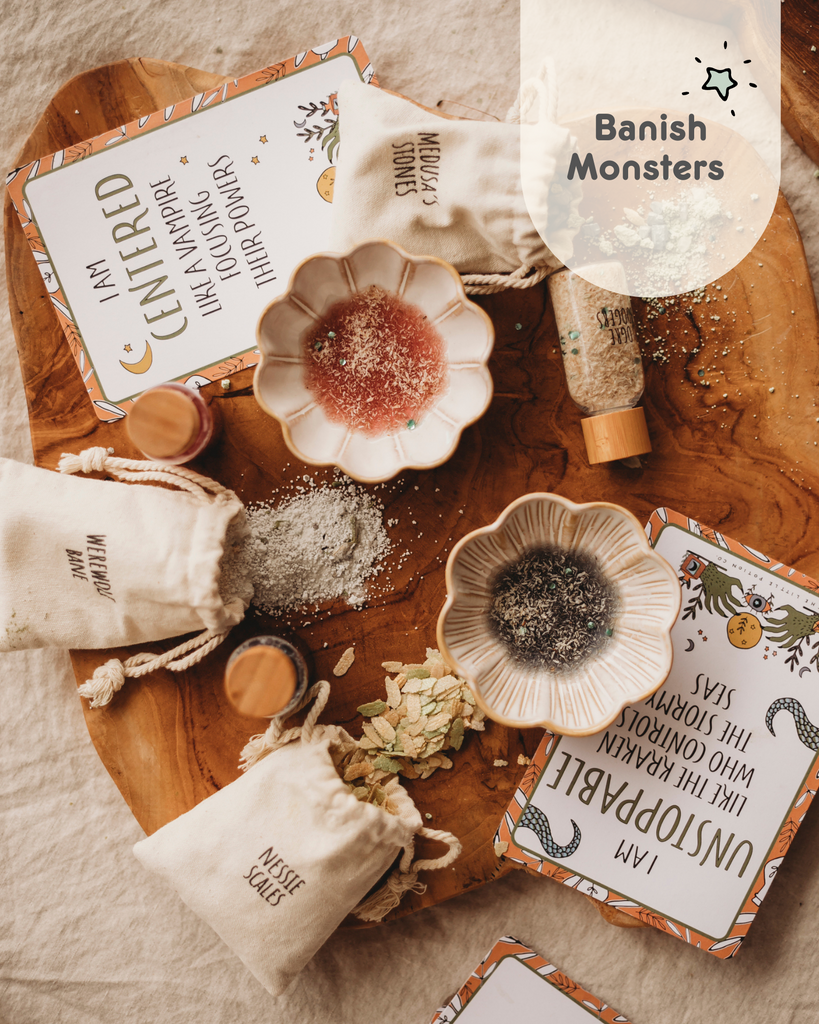 Monster mashup mindful potion kit. Images shows potion kit ingredients layed out on wooden board, along with affirmation cards that read. I am Centered like a Vam[ire focusing their powers and I am Unstoppable like the Kraken who controls the stormy seas. 